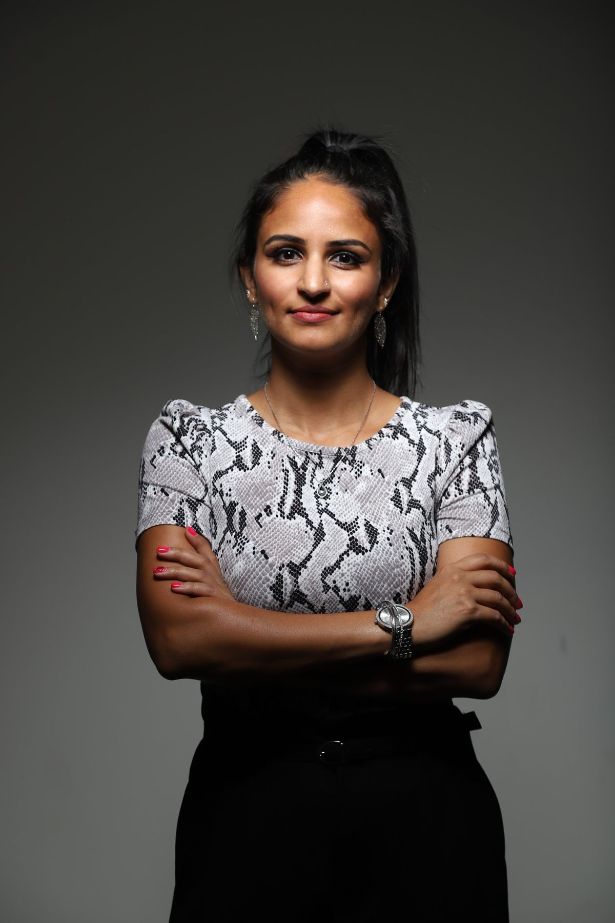Taniya Refai, Northeast Florida real estate agent, arms crossed in a studio portrait